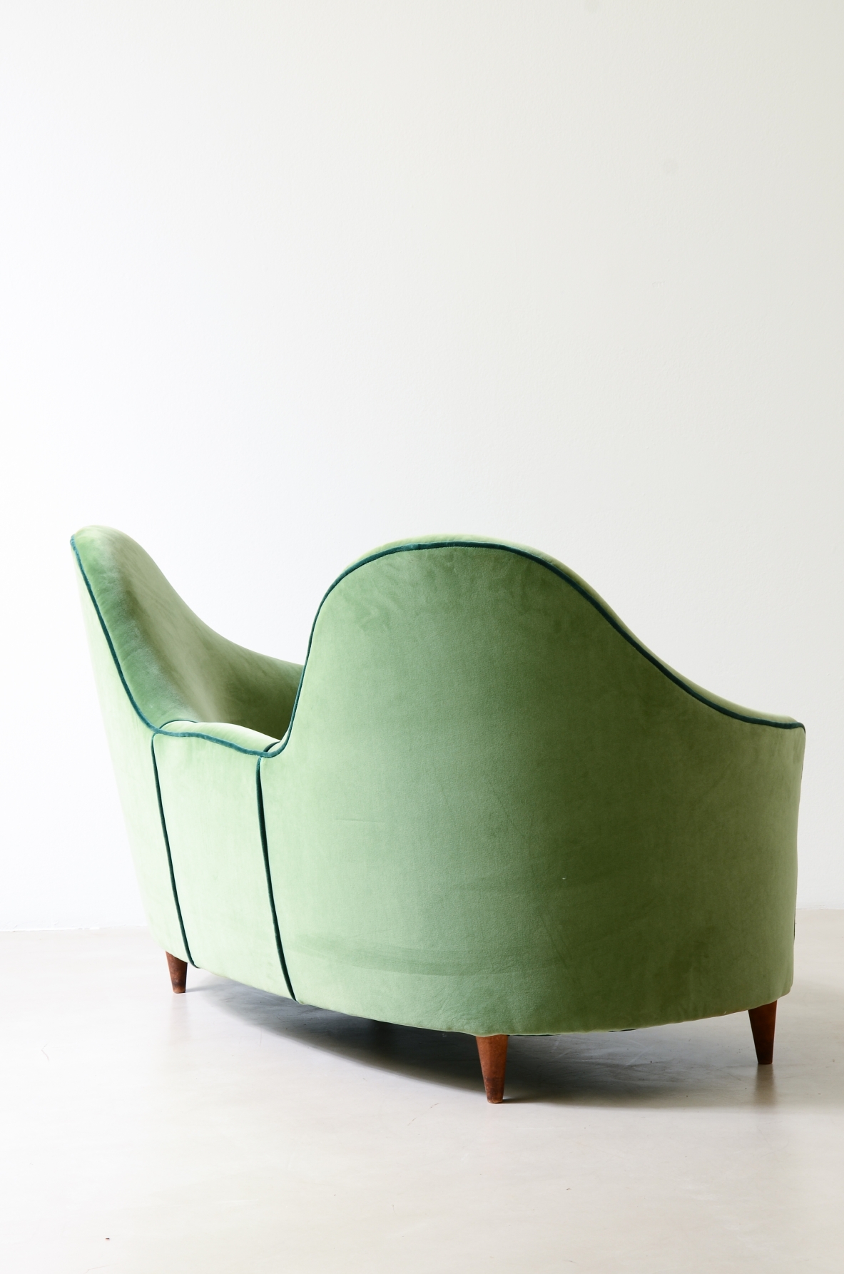 Cesare Lacca  A rare two-seater sofa with enveloping lines, Turned wooden legs.  Italian manufacture, 1950s