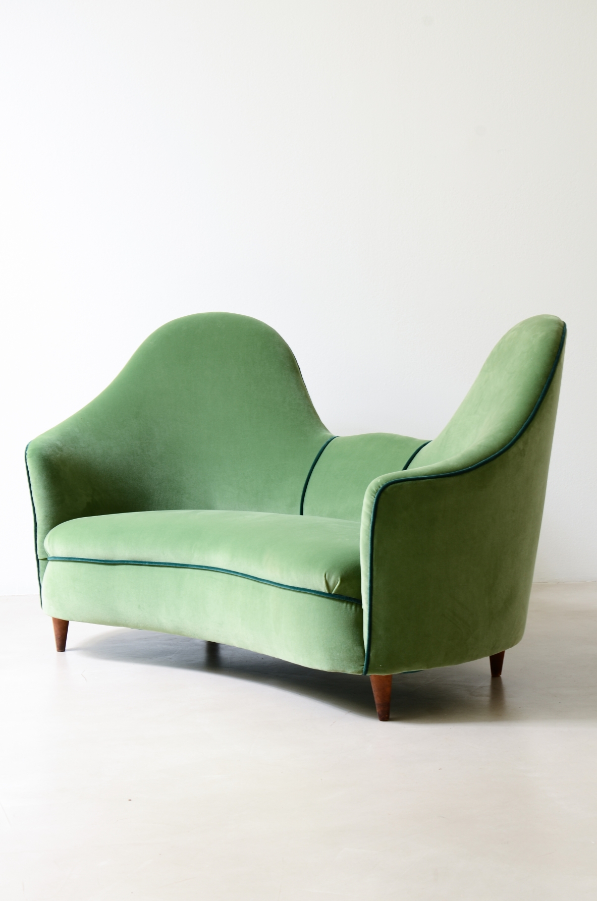 Cesare Lacca  A rare two-seater sofa with enveloping lines, Turned wooden legs.  Italian manufacture, 1950s