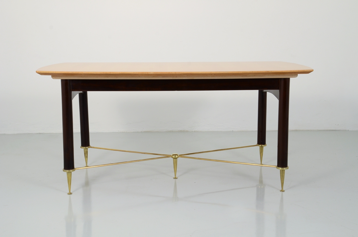 Maison Raphael Parigi, elegante tavolo con allungh. Base in legno tinto e piano in acero. Elegante crociera in ottone tornito. Parigi, 1950ca.