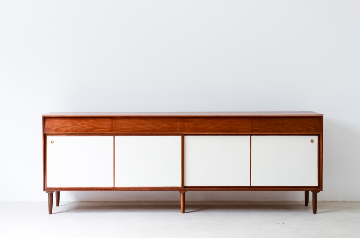 Credenza in legno con cassetti e pannelli scorrevoli con rivestimento in pelle. Manifattura italiana, 1950ca.