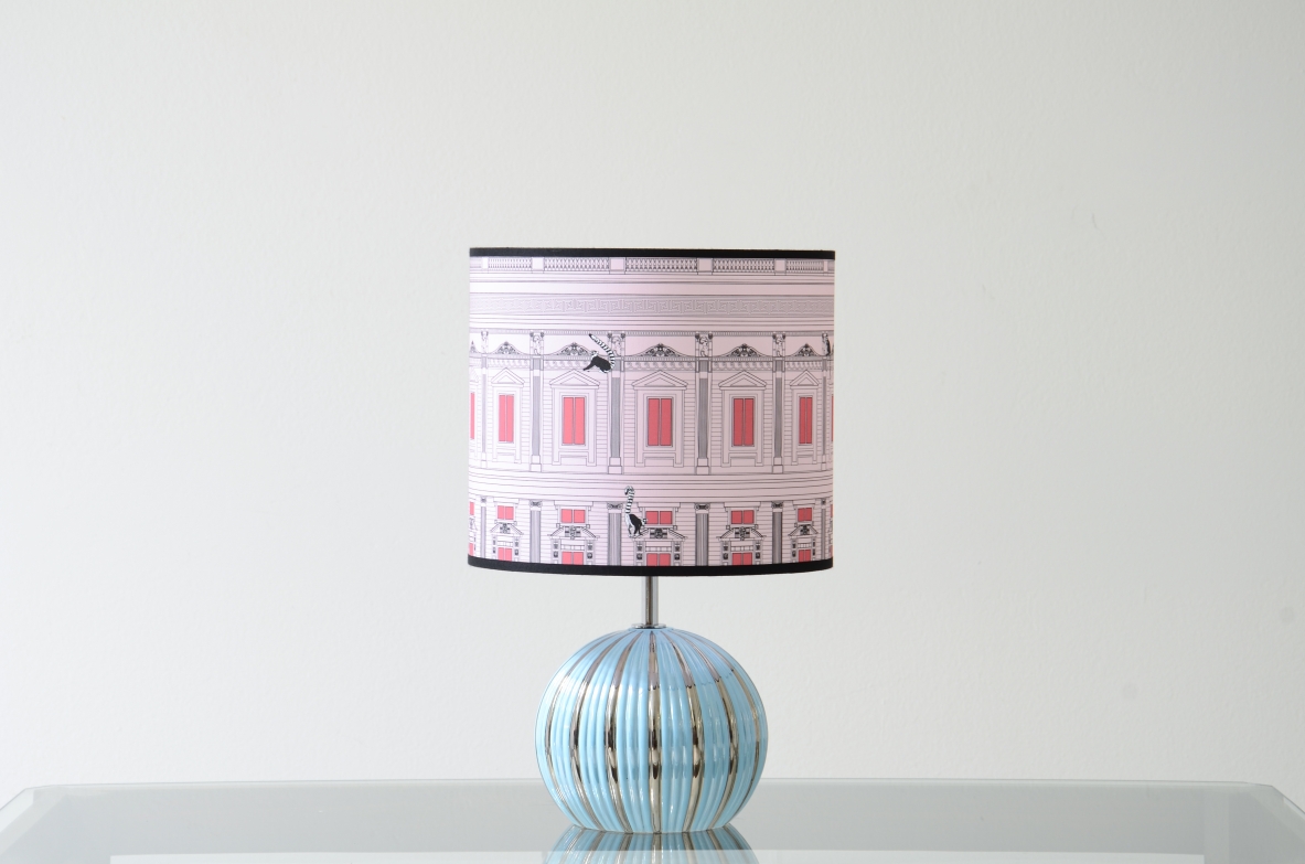 Table lamp with original 1950s ceramic base and fabric cap printed in the style of Piero Fornasetti.