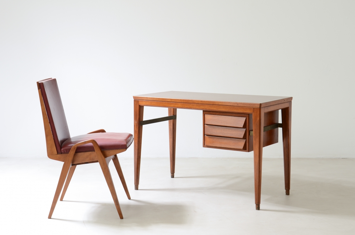 Gio Ponti (1891-1979)  Elegante scrivania in rovere disegnata da Gio Ponti per la Banca Nazionale del Lavoro. Gambe leggermente curvate unite da un distanziale in ottone, tre cassetti con fronte sagomato.