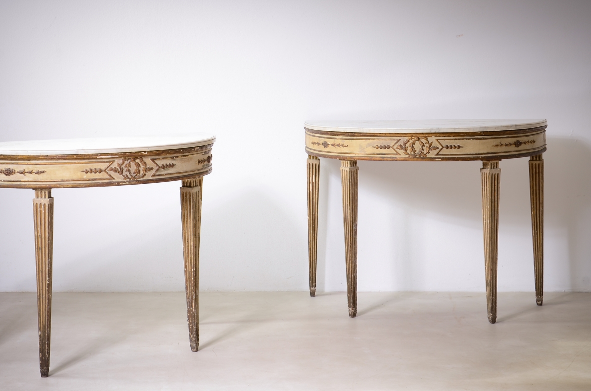 Pair of elegant half-moon console tables in lacquered and gilded wood, Louis XVI period, ca. 1770.